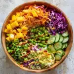 Crispy Rice Salad Recipe: Make the Best Crunchy Vegan Dish in 4 Easy Steps 8 Overhead view of crispy rice salad in a wooden bowl with mango, edamame, cucumber, and cabbage