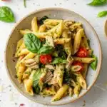 Easy Tuna Pesto Pasta Recipe: The Best 25-Minute Dinner 10 Flat lay of a clean recipe card for tuna pesto pasta, showing ingredients and cooking steps alongside a bowl of penne pasta with tuna, pesto, spinach, and cherry tomatoes.