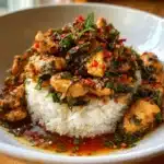Thai Basil Chicken Recipe – Easy, Spicy, 20-Minute Dinner 10 Close-up of Thai Basil Chicken served over jasmine rice with fresh basil and chopped red chilies